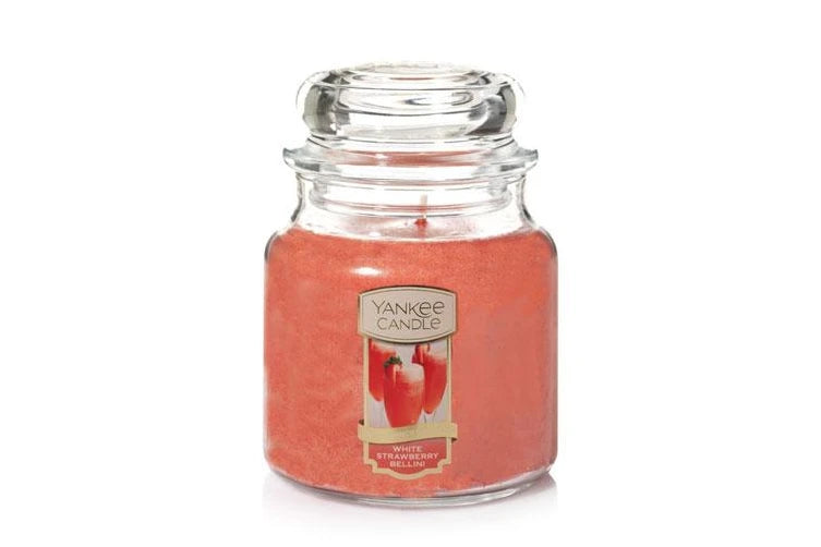 Yankee Candle Medium Jar in White Strawberry Bellini scent, featuring a classic glass jar with dome lid, emitting a sweet and invigorating fragrance.
